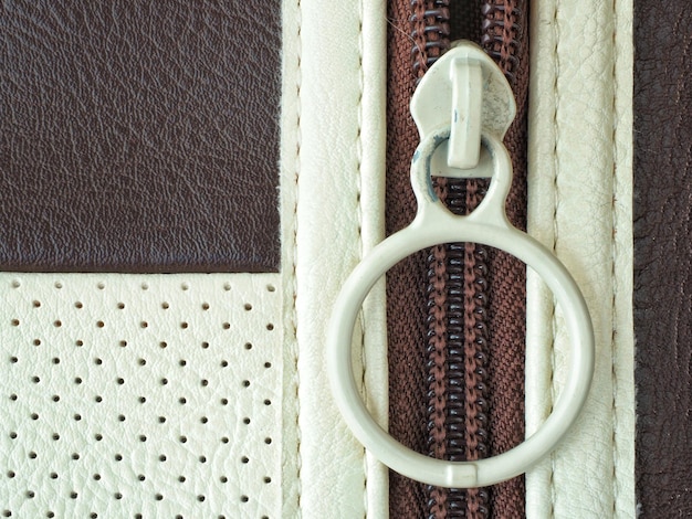 Close-up comparison of the hardware (zipper and logo) on a genuine vs. fake luxury wallet. Differences in the finish and engraving are clearly visible.