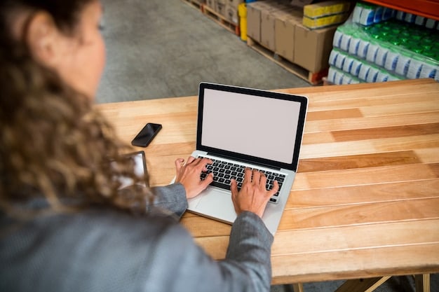 A person sitting at a desk, using a laptop to browse Shopee. Next to the laptop, there's a notebook with a handwritten list titled 