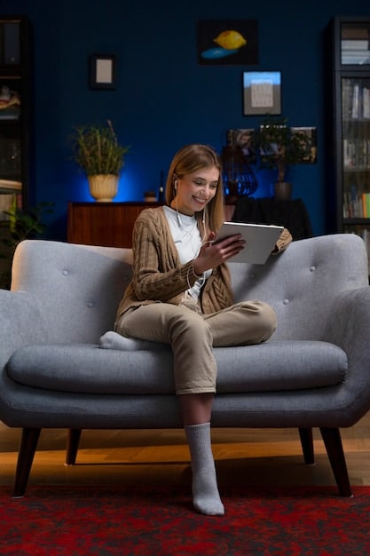A woman uses an AR app on her tablet to visualize a new sofa in her living room. The app allows her to change the color and size of the sofa to see how it fits with her decor. The background shows the actual living room setting, providing a realistic comparison.