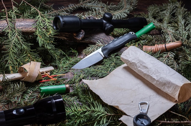 A close-up shot of various outdoorsy gifts, such as a high-quality camping knife, a durable water bottle, and a portable camping stove, all arranged on a wooden surface with a blurred natural background. The lighting should be soft and inviting, highlighting the textures of the products and creating a sense of adventure and practicality.