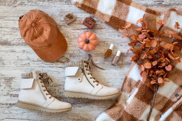 A flat lay of various Shein fall fashion items in rich earth tones, including a chunky knit sweater, a suede mini skirt, a wide-brimmed hat, and ankle boots, all neatly arranged.