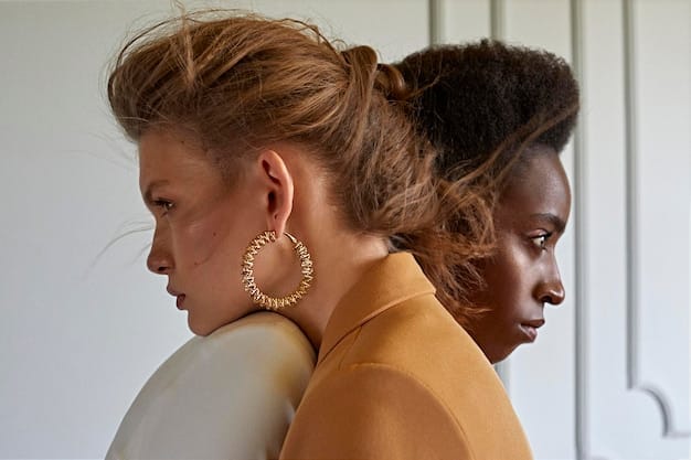 A close-up shot of a diverse collection of Shein earrings, including large hoops, delicate studs, and elaborate dangle earrings, arranged artfully on a velvet display, showcasing various materials and designs.