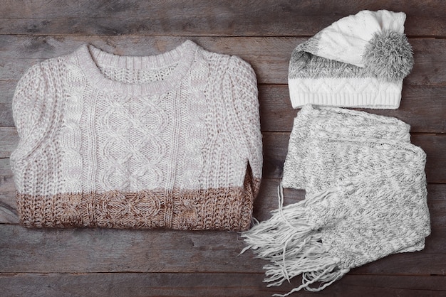 A flat lay showing various Shein layering pieces like a thin thermal top, a chunky knit sweater, a versatile vest, and a long coat, arranged to illustrate how they can be combined for different looks.