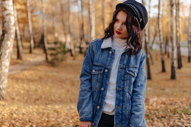 A stylish person bundled up in a warm Shein denim jacket with a faux fur collar, paired with dark-wash jeans and cozy knit accessories, walking through a leafy park in autumn.