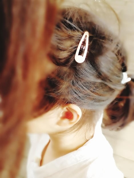 A close-up shot of a chic hair claw clip, featuring a translucent amber design, elegantly holding a styled bun, showcasing modern simplicity and functionality.
