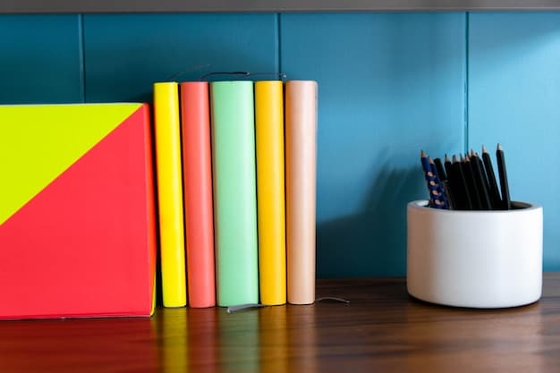 A stack of colorful student handbooks and textbooks on a dormitory desk, with a laptop open to the Shein website displaying various clothing items and a prominent 