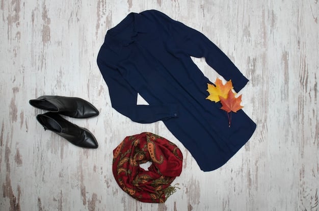 A detailed flat lay of a professional workwear outfit for a woman. It includes a sleek black sheath dress, a structured light grey blazer, a pair of classic black pumps, and a minimalist silver watch, all laid out neatly on a light wood surface.