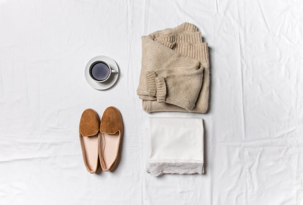 A flat lay of a minimalist capsule wardrobe selection for casual wear, featuring a white oversized t-shirt, beige wide-leg trousers, a denim jacket, a black knit midi dress, and a pair of white fashion sneakers, all neatly folded.