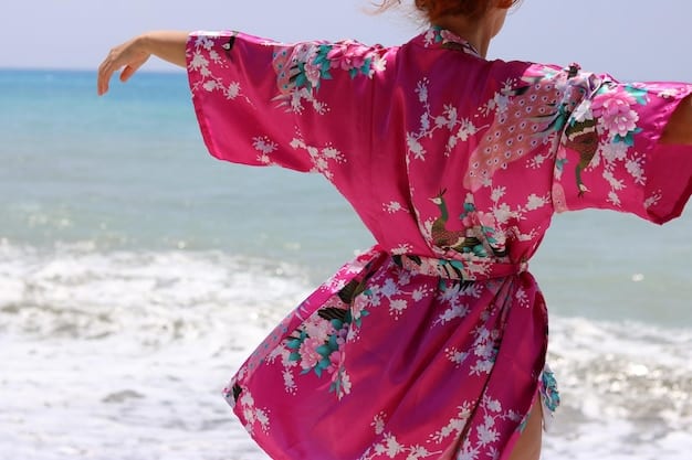 A detailed flat lay showcasing resort wear, with a vibrant tropical print kimono layered over a striped bikini top, complemented by a wide-brimmed straw hat and oversized sunglasses, all from Shein's collection.