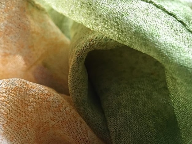 A close-up shot of various eco-friendly fabrics such as organic cotton, hemp, and recycled polyester, displaying their textures and weaves. The focus is on the tactile qualities of the materials and their natural appearances, highlighting Sustainable Style: How Eco-Friendly Fabrics Are Redefining US Fashion Trends.