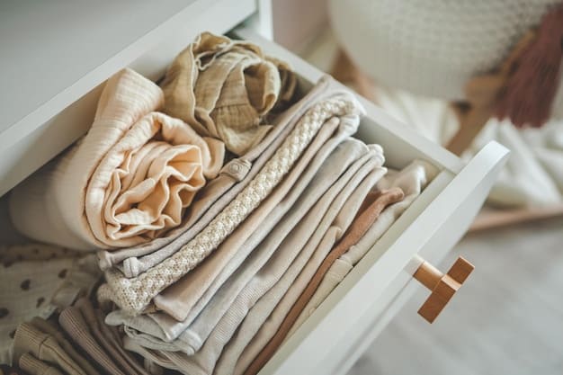 Neutral-colored essential capsule wardrobe pieces neatly hung and folded in a closet. Items include a trench coat, a cashmere sweater, straight-leg jeans, and a white button-down shirt, representing classic capsule wardrobe essentials: building a versatile US fashion collection.