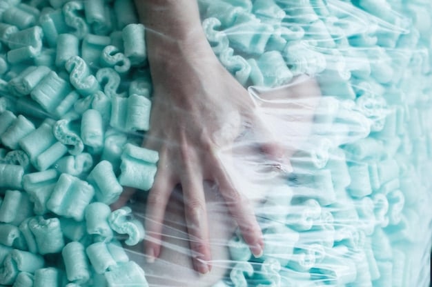 Close-up shot of a hand touching a fabric made from recycled plastic bottles. The texture of the fabric is high-quality and stylish, debunking the myth that sustainable materials are inferior. The image emphasizes the innovation and aesthetics of sustainable fashion in relation to The Future of Fashion: Exploring Innovative Technologies and Materials in the US.