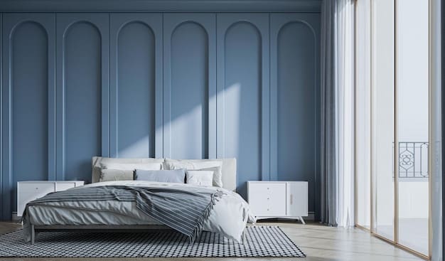 A minimalist bedroom featuring a wall painted in a soft, muted blue. The room includes a white bed with pastel pink and blue cushions, a light wooden bedside table, and a simple, modern lamp. Natural light filters in through a sheer curtain, creating a serene and calming atmosphere that highlights the soothing quality of the pastel blue wall.