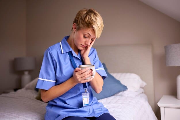 A close-up shot of a nurse looking exhausted, sitting alone in a break room. The image highlights the emotional toll of healthcare work and the need for burnout prevention strategies. The scene is dimly lit to emphasize the feeling of isolation.
