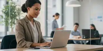 Professional woman working remotely with laptop in a modern office setting.
