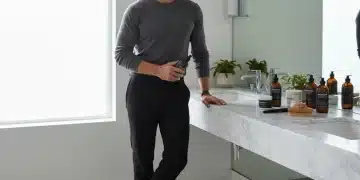 Modern man grooming in a sleek bathroom, surrounded by premium grooming products.