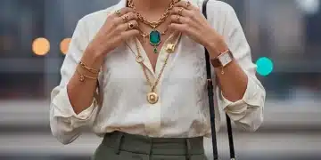 Stylish woman adjusting statement necklace, demonstrating outfit elevation with accessories.